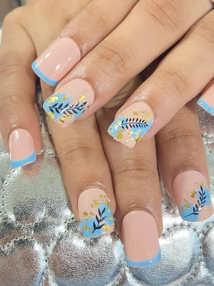 A beautiful French tip design with a touch of nature. This set features a light blue French tip with delicate hand-painted leaves and gold foil accents.