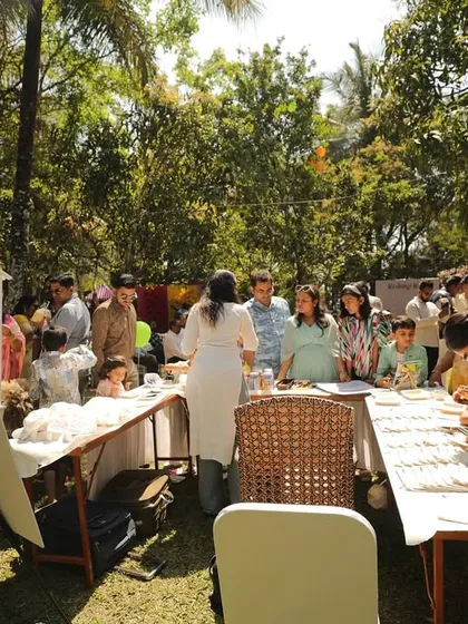 An overview of the bustling DIY art station at a sunny, outdoor wedding carnival. There was something for everyone to create.