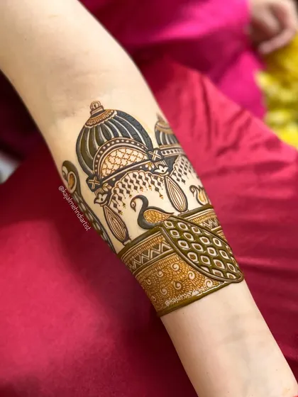 A close-up of an arm cuff design featuring a royal palace and peacock, a statement piece for any wedding guest.