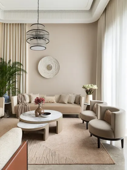 The formal living room of the Juneja Residence is a study in texture and tone. The monochromatic palette of beige and cream creates a serene, calming atmosphere, perfect for intimate conversations.