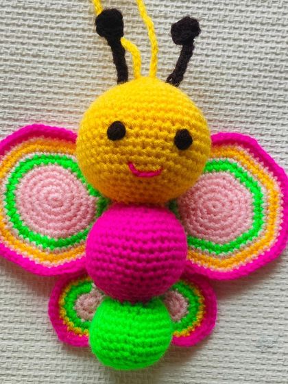 A very cute and colorful crochet butterfly. I used bright yellow, pink, and green yarn to make it. This can be a toy or even a decoration for a child's room.