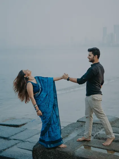 A candid moment of connection by the sea, with the Mumbai skyline in the distance. My focus is on capturing the natural movement and emotion between a couple, creating dynamic and heartfelt seaside romance photos.