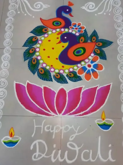 A symmetrical design featuring a pair of peacocks, a large lotus flower, and small diyas. This style of rangoli is balanced and colorful, ideal for a central space in a home.