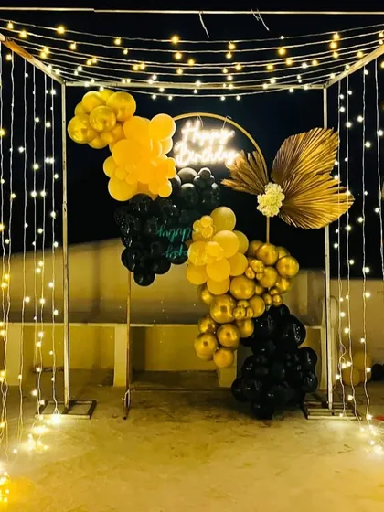 The full view of the fairy light canopy and balloon arrangement, creating an enchanting entrance or photo spot for an evening party.