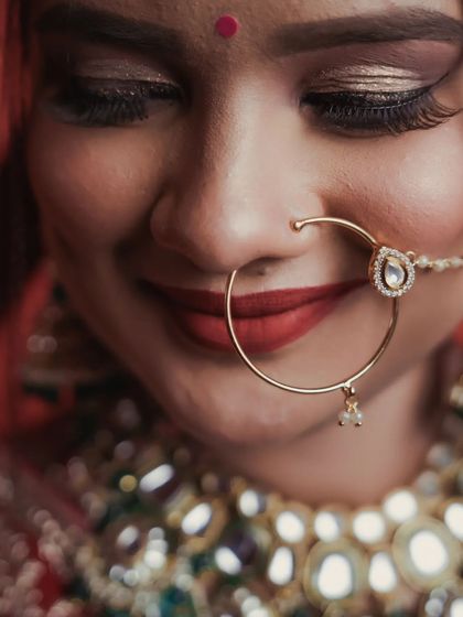 This macro shot focuses on the bride's gentle smile and the elegant simplicity of her bridal nath. It's a detail-oriented portrait that highlights the subtle beauty and emotion of the moment.