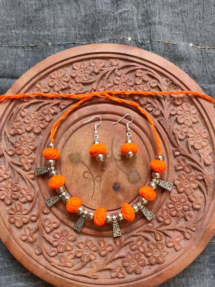 This thread bead necklace is available in a variety of colors like orange, green, yellow, blue, and red. It's a simple yet elegant accessory, perfect for adding a pop of color to your festive wear.