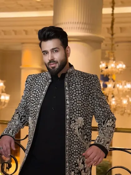 A client looking regal in a custom black and silver sherwani. The detailed embroidery gives the outfit a luxurious feel, perfect for a grand wedding reception.