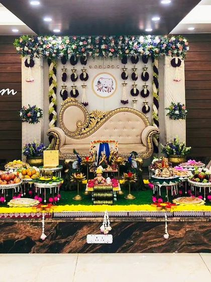 A wide view of a baby shower setup, showcasing the symmetry of the decor with two tall floral lamps flanking the central stage.
