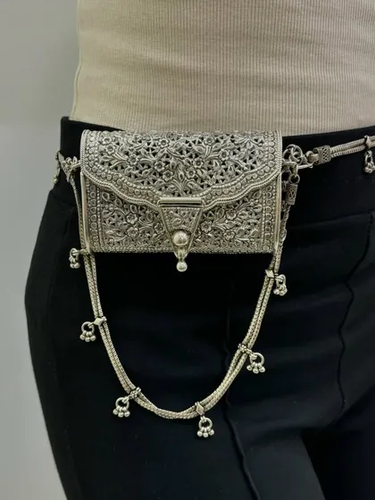 Another view of the versatile silver purse. The detailed craftsmanship and unique design make it a standout accessory, whether worn as a clutch or around the waist.