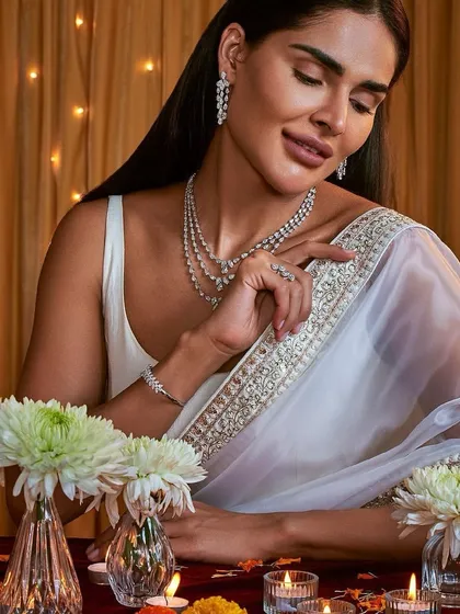 An ethereal and elegant festive look. The makeup is soft and luminous, with a neutral palette that works beautifully with the white and silver saree, creating a serene and graceful vibe.