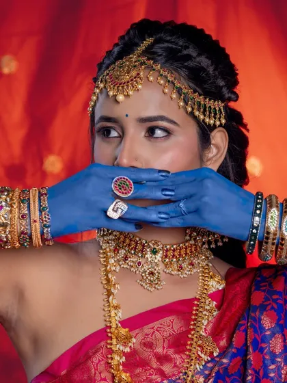 A creative pose that draws attention to both the intricate hairstyle and the bold, artistic elements of the shoot.