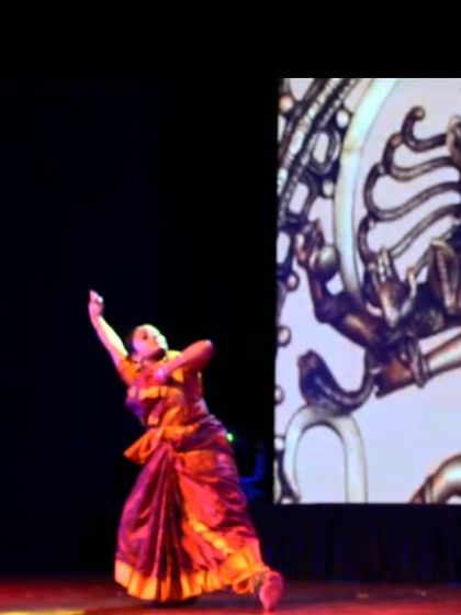 A powerful moment from a classical Bharatanatyam performance, set against a backdrop of Lord Shiva as Nataraja. We believe in expressing stories and emotions through every movement.