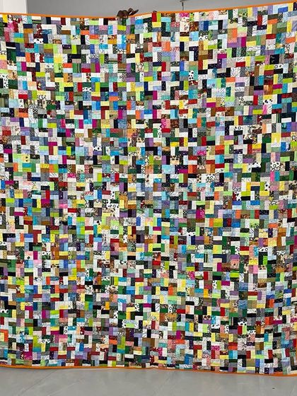 An incredibly dense and colorful scrappy quilt, demonstrating a "no scrap left behind" philosophy.