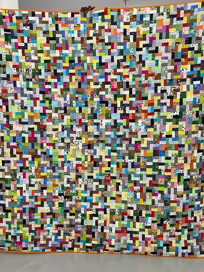 An incredibly dense and colorful scrappy quilt, demonstrating a "no scrap left behind" philosophy.