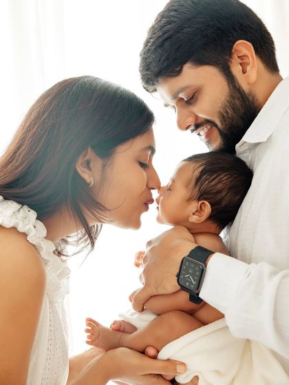 An intimate family moment, with mom and dad sharing an eskimo kiss with their baby. These are the playful, loving interactions I look for.