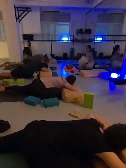 The calm, blue-lit ambiance of our Yin Yoga session, where students hold poses for several minutes to target deep connective tissues.