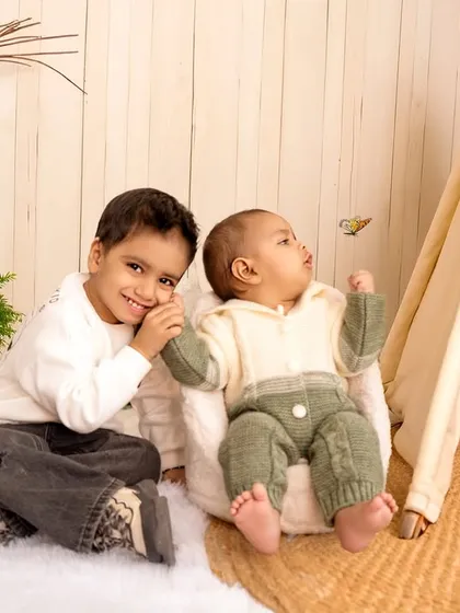 A sweet moment between two brothers in a cozy, boho-themed studio setup. Capturing sibling interactions is a key part of my family photography service.