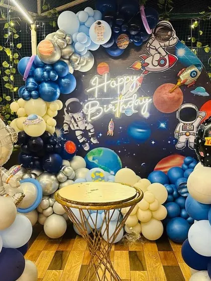 A "First Trip Around the Sun" space theme, perfect for a baby's first birthday. This detailed setup includes a galaxy backdrop, planet and astronaut cutouts, a custom neon sign, and a full balloon arch creating an out-of-this-world celebration.