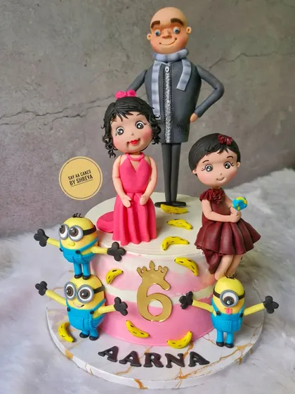 Bello! This fun cake celebrates a double birthday with a Minions theme. It features Gru and his mischievous Minions as handmade figurines, surrounded by their favorite thing: bananas.