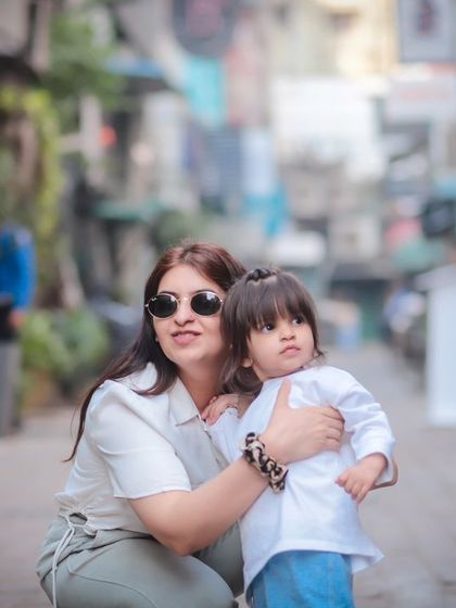 A mother holds her daughter close during their walk. This outdoor session captures the simple, loving moments of everyday life.