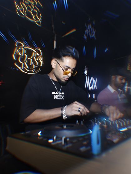 In the zone, mixing tracks in a dark club environment with neon lights. This is a typical night for me, delivering sets that blend hip hop, commercial, and electronic music.