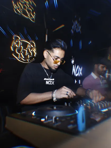 In the zone, mixing tracks in a dark club environment with neon lights. This is a typical night for me, delivering sets that blend hip hop, commercial, and electronic music.