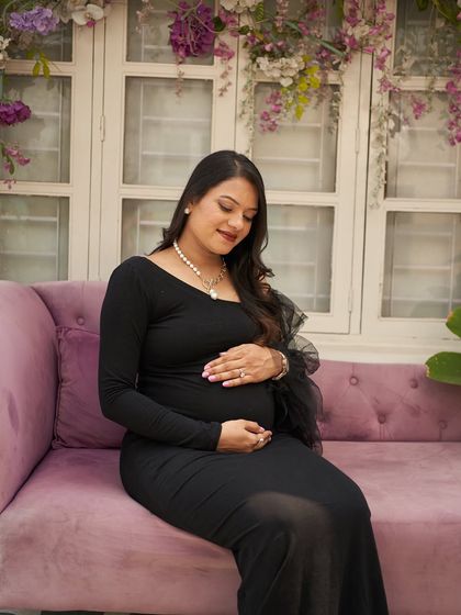 A serene moment on the purple couch in our studio. The long-sleeved Zelda gown is a comfortable and chic option.
