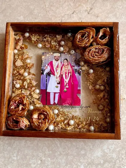 A simple yet elegant 8-inch teakwood frame preserving a couple's wedding flowers. The natural wood grain complements the preserved roses and pearls beautifully.