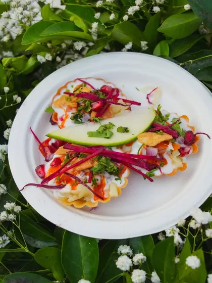 Bringing the vibrant flavors of Indian street food to your event. This is a plate of my special chaat, featuring crispy elements, tangy chutneys, yogurt, and fresh garnishes.