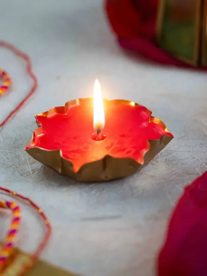 A simple yet beautiful red wax candle poured into a golden, fluted container. It glows so warmly when lit, perfect for a festive evening.