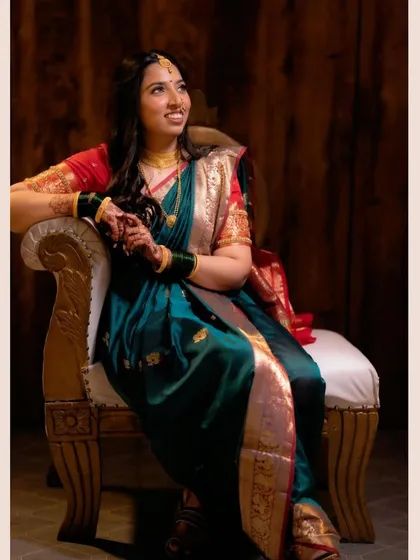 A full portrait of the guest, looking poised and beautiful in her traditional saree and subtle makeup.