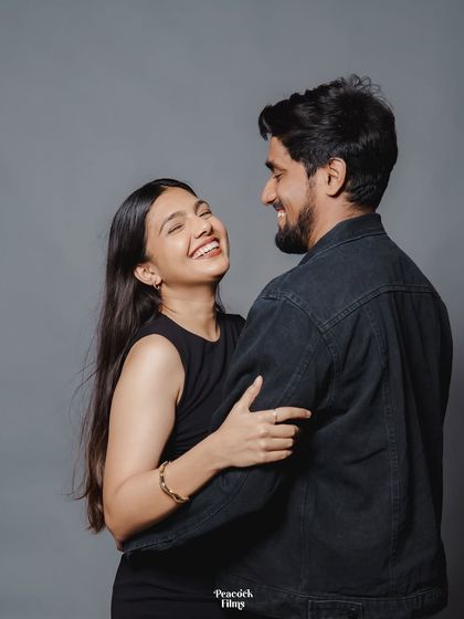 A joyful, candid moment in the studio. The bride's bright laugh and the couple's easy interaction make this pre-wedding portrait feel incredibly genuine and full of life.