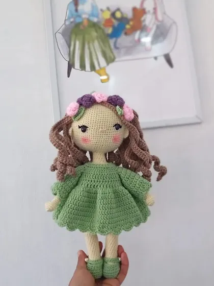 A still photo of my original doll design with a flower crown and a lovely green dress, perfect for anyone looking for a unique handmade gift.