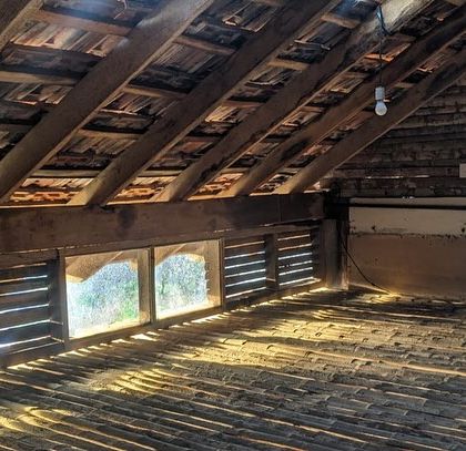 Another view of the simple, functional attic space at Unnathi Farm, illuminated by natural light.