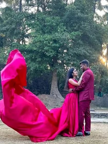 This pink satin long-tail gown is paired with a matching suit for the groom, creating a perfectly coordinated look for a pre-wedding shoot.