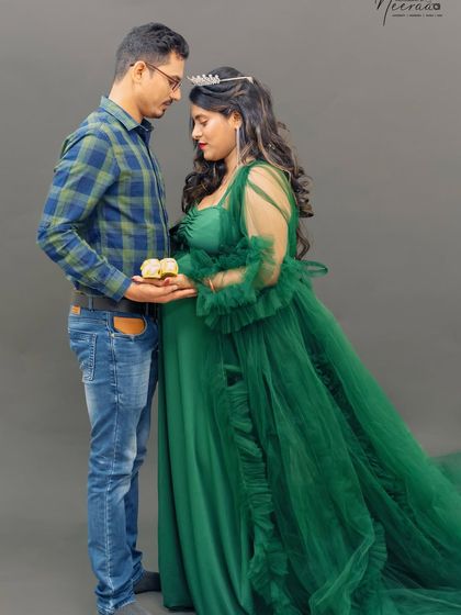 A tender moment between the parents-to-be. Holding tiny baby shoes together is a sweet reminder of the little life they are about to welcome.