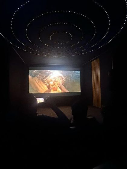Another view of the completed 7.2.4 home theater, showing the large projection screen in action. I use professional CEDIA standard design software to optimize speaker placement, ensuring you get the best possible audio performance.