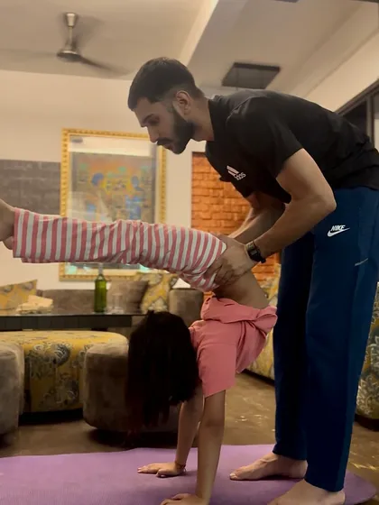 Another angle of assisting Nandini. You can see how I help her extend her leg while maintaining the integrity of the backbend, combining flexibility with stability.