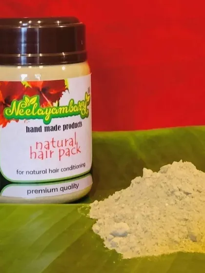 My Natural Hair Pack powder on a fresh banana leaf. This pack is a blend of more than 20 potent herbs designed for deep conditioning, giving your hair volume and a beautiful shine.