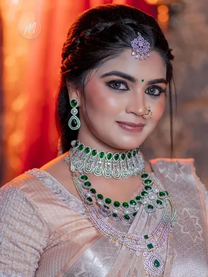 A detailed close-up of the eye makeup and the stunning emerald necklace.