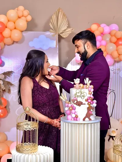 A beautiful moment captured as the parents-to-be cut their cake. Our 'Baby in Bloom' decor, with its organic balloon arch and custom backdrop, provides the perfect setting for these cherished memories.