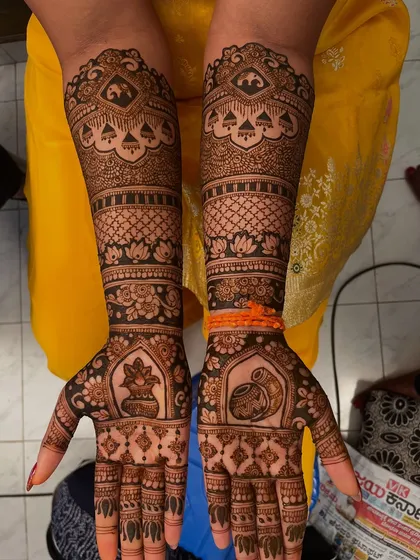 A complete view of a traditional bridal mehendi design. The symmetrical patterns extend up to the elbows, featuring classic motifs like kalash pots, elephants, and lotuses for a grand and timeless look.