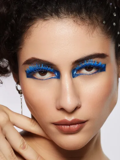 A bold and futuristic look with glossy blue lashes and liner, creating a stunning and unique eye statement.