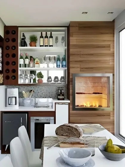 This setup is designed for the ultimate host, featuring a built-in fireplace, a dedicated wine bottle rack, extensive shelving for spirits, and space for a coffee machine and dishwasher. It effectively creates a full-service kitchen and bar on the balcony.