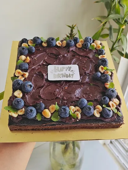 Healthy can be delicious too. This is a gluten-free, sugar-free, and dairy-free chocolate cake I made using almond and ragi flour, sweetened with dates, and topped with a rich ganache, fresh blueberries, and hazelnuts.