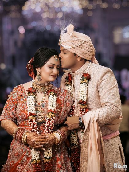 A beautiful, intimate moment as the groom kisses his bride's forehead, their eyes closed in a moment of pure love.