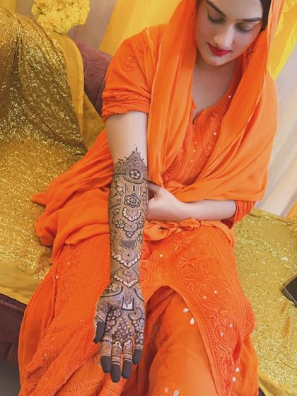 Another stunning shot of Noora. The contrast between her orange dress and the dark henna is just perfect.