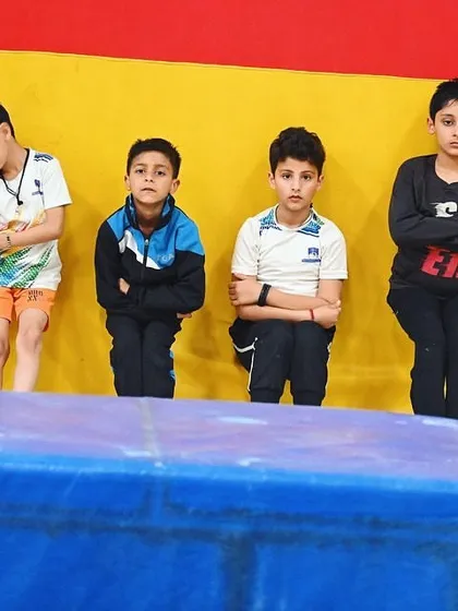 A group of young boys waiting for their turn, focused and ready for the next drill.