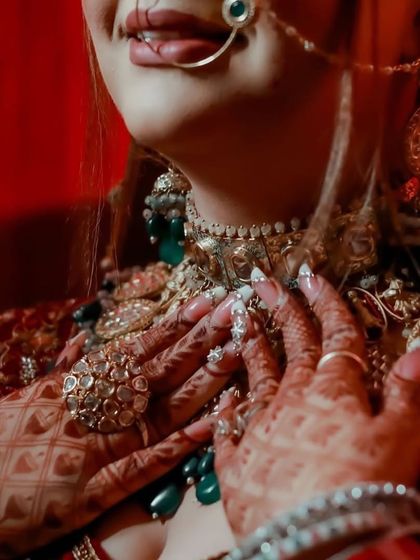 An artistic close-up of the bride's hands, rings, and the lower part of her necklace.