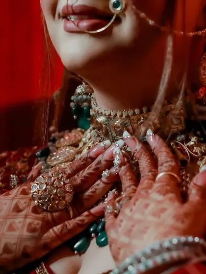 A detailed shot of the bride's henna-adorned hands and the stunning, oversized rings that are part of her bridal set.